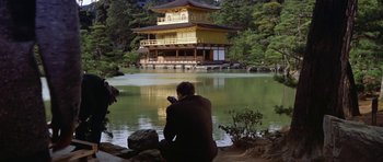 Movie still from “My Geisha” (1962), directed by Jack Cardiff – A man taking a picture of a building by a lake; Extreme Wide shot, Low angle