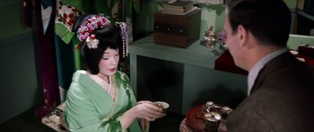 Movie still from “My Geisha” (1962), directed by Jack Cardiff – A geisha in a green kimono is holding a tea cup; Medium shot, High angle