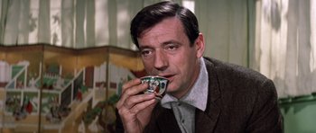 Movie still from “My Geisha” (1962), directed by Jack Cardiff – A man is holding a cup in his hand; Close Up shot, Low angle
