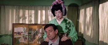 Movie still from “My Geisha” (1962), directed by Jack Cardiff – A woman in a geisha outfit is sitting on a man's shoulders; Medium shot, High angle