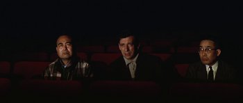 Movie still from “My Geisha” (1962), directed by Jack Cardiff – A man sitting in a movie theater in the dark; Medium shot, Low angle