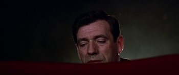 Movie still from “My Geisha” (1962), directed by Jack Cardiff – A person sitting in front of a table; Close Up shot, Low angle