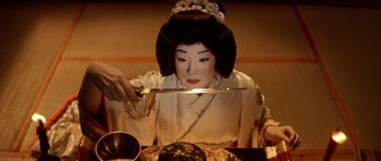Movie still from “My Geisha” (1962), directed by Jack Cardiff – A geisha is holding a knife in front of a bowl of soup; Close Up shot, High angle