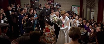 Movie still from “My Geisha” (1962), directed by Jack Cardiff – A bride and groom walking down the aisle at a wedding; Medium shot, Over the shoulder angle