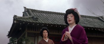 Movie still from “My Geisha” (1962), directed by Jack Cardiff – Two geishas are standing in front of a building; Medium shot, Low angle