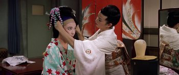 Movie still from “My Geisha” (1962), directed by Jack Cardiff – A man putting a flower in a woman's hair; Medium shot, Over the shoulder angle