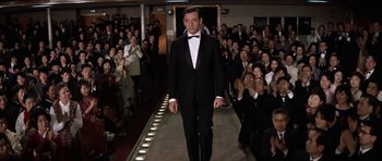 Movie still from “My Geisha” (1962), directed by Jack Cardiff – A man in a tuxedo walking down a runway; Wide shot, Low angle