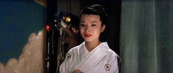 Movie still from “My Geisha” (1962), directed by Jack Cardiff – A woman in a white kimono is posing for a picture; Close Up shot, Low angle