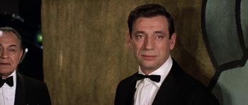 Movie still from “My Geisha” (1962), directed by Jack Cardiff – A person wearing a suit and bow tie; Close Up shot, Low angle