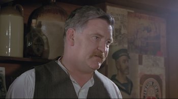 Movie still from “My Left Foot” (1989), directed by Jim Sheridan – A person wearing a suit and tie; Close Up shot, Low angle