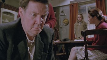 Movie still from “My Left Foot” (1989), directed by Jim Sheridan – A man sitting in front of a mirror in front of a woman; Close Up shot, Low angle