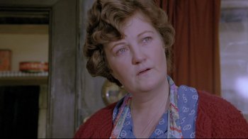 Movie still from “My Left Foot” (1989), directed by Jim Sheridan – An older woman wearing a blue shirt and a red sweater; Close Up shot, Low angle