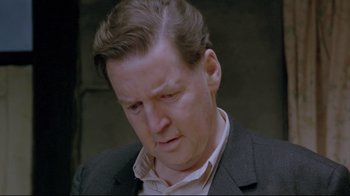 Movie still from “My Left Foot” (1989), directed by Jim Sheridan – A person wearing a suit and tie; Close Up shot, High angle
