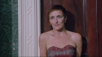 Movie still from “My Left Foot” (1989), directed by Jim Sheridan – A woman in a strapless dress posing for a picture; Close Up shot, Low angle