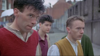 Movie still from “My Left Foot” (1989), directed by Jim Sheridan – Three young men standing on the side of the street; Medium shot, Low angle