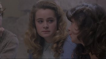 Movie still from “My Left Foot” (1989), directed by Jim Sheridan – A woman with long blonde curly hair looking at a woman with long blonde curly hair; Close Up shot, Over the shoulder angle