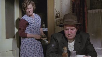 Movie still from “My Left Foot” (1989), directed by Jim Sheridan – A man and a woman in a kitchen; Medium shot, Over the shoulder angle