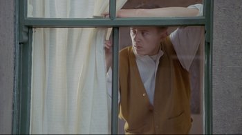 Movie still from “My Left Foot” (1989), directed by Jim Sheridan – A man standing in front of a window looking out; Medium shot, Low angle
