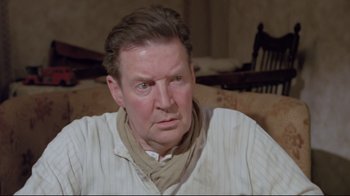 Movie still from “My Left Foot” (1989), directed by Jim Sheridan – A person sitting on a couch; Close Up shot, Over the shoulder angle