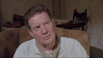 Movie still from “My Left Foot” (1989), directed by Jim Sheridan – A person sitting on a couch; Close Up shot, Over the shoulder angle