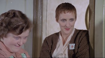 Movie still from “My Left Foot” (1989), directed by Jim Sheridan – A woman in a brown jacket is talking to a boy; Close Up shot, Over the shoulder angle