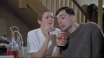 Movie still from “My Left Foot” (1989), directed by Jim Sheridan – A man and a woman are eating food together; Medium shot, Low angle