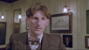Movie still from “My Left Foot” (1989), directed by Jim Sheridan – A man wearing a suit and a bow tie; Close Up shot, Low angle