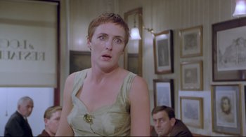 Movie still from “My Left Foot” (1989), directed by Jim Sheridan – A woman with short red hair is looking at the camera; Close Up shot, Over the shoulder angle