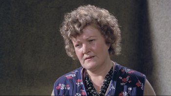 Movie still from “My Left Foot” (1989), directed by Jim Sheridan – An older woman wearing a blue floral shirt; Close Up shot, High angle