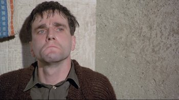 Movie still from “My Left Foot” (1989), directed by Jim Sheridan – A person wearing a brown sweater; Close Up shot, Low angle