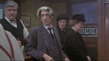 Movie still from “My Left Foot” (1989), directed by Jim Sheridan – An older man in a pinstriped suit and hat; Medium shot, Over the shoulder angle