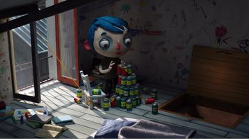 Movie still from “My Life as a Zucchini” (2016), directed by Claude Barras – An animated character sitting on a chair next to a pile of cans; Wide shot, High angle
