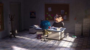 Movie still from “My Life as a Zucchini” (2016), directed by Claude Barras – A person sitting at a desk in front of a giant head; Wide shot, High angle