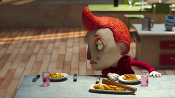 Movie still from “My Life as a Zucchini” (2016), directed by Claude Barras – A red haired boy sitting at a table with some fries; Medium shot, Over the shoulder angle