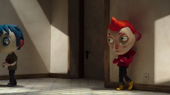 Movie still from “My Life as a Zucchini” (2016), directed by Claude Barras – A red haired doll standing next to a door; Medium shot, High angle