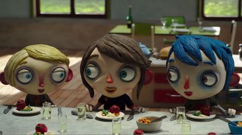 Movie still from “My Life as a Zucchini” (2016), directed by Claude Barras – A group of people sitting at a table with a plate of food on it; Medium shot, High angle