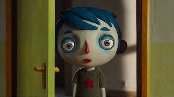 Movie still from “My Life as a Zucchini” (2016), directed by Claude Barras – A blue haired doll with a red star on its head; Close Up shot, Overhead angle