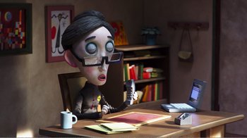 Movie still from “My Life as a Zucchini” (2016), directed by Claude Barras – A man sitting at a desk with a laptop; Medium shot, High angle