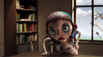 Movie still from “My Life as a Zucchini” (2016), directed by Claude Barras – A doll with a blue hat is sitting on a table; Close Up shot, Low angle