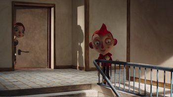 Movie still from “My Life as a Zucchini” (2016), directed by Claude Barras – A large red head doll sitting on the stairs; Wide shot, High angle