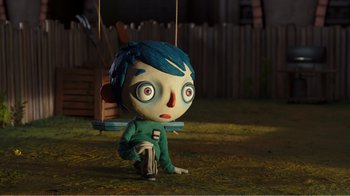 Movie still from “My Life as a Zucchini” (2016), directed by Claude Barras – A cartoon character sitting on the ground with a swing in front of him; Wide shot, High angle