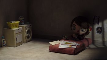 Movie still from “My Life as a Zucchini” (2016), directed by Claude Barras – A doll sitting on the floor next to a washing machine; Wide shot, High angle