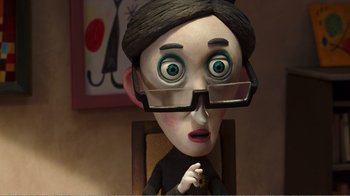 Movie still from “My Life as a Zucchini” (2016), directed by Claude Barras – A cartoon of a woman with glasses and a black suit; Close Up shot, Over the shoulder angle