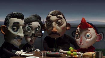 Movie still from “My Life as a Zucchini” (2016), directed by Claude Barras – A group of people sitting at a table with a plate of fruit; Medium shot, Over the shoulder angle