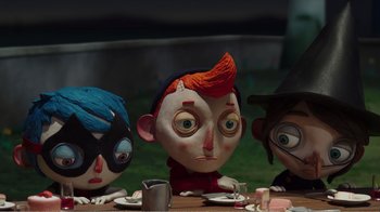 Movie still from “My Life as a Zucchini” (2016), directed by Claude Barras – A group of people sitting at a table with a cup; Medium shot, High angle
