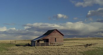 Movie still from “My Own Private Idaho” (1991), directed by Gus Van Sant – An old barn sits in the middle of a dry grass field; Extreme Wide shot, Low angle