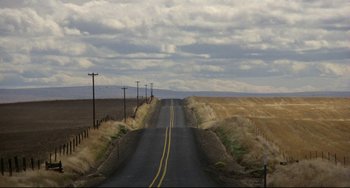Movie still from “My Own Private Idaho” (1991), directed by Gus Van Sant – An empty road in the middle of a field; Extreme Wide shot, High angle