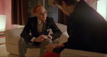 Movie still from “My Own Private Idaho” (1991), directed by Gus Van Sant – Two people sitting on a couch talking to each other; Medium shot, Over the shoulder angle