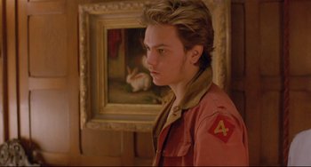 Movie still from “My Own Private Idaho” (1991), directed by Gus Van Sant – A young man standing in front of a painting of a rabbit; Close Up shot, Over the shoulder angle