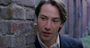 Movie still from “My Own Private Idaho” (1991), directed by Gus Van Sant – A person leaning against a brick wall; Close Up shot, Over the shoulder angle